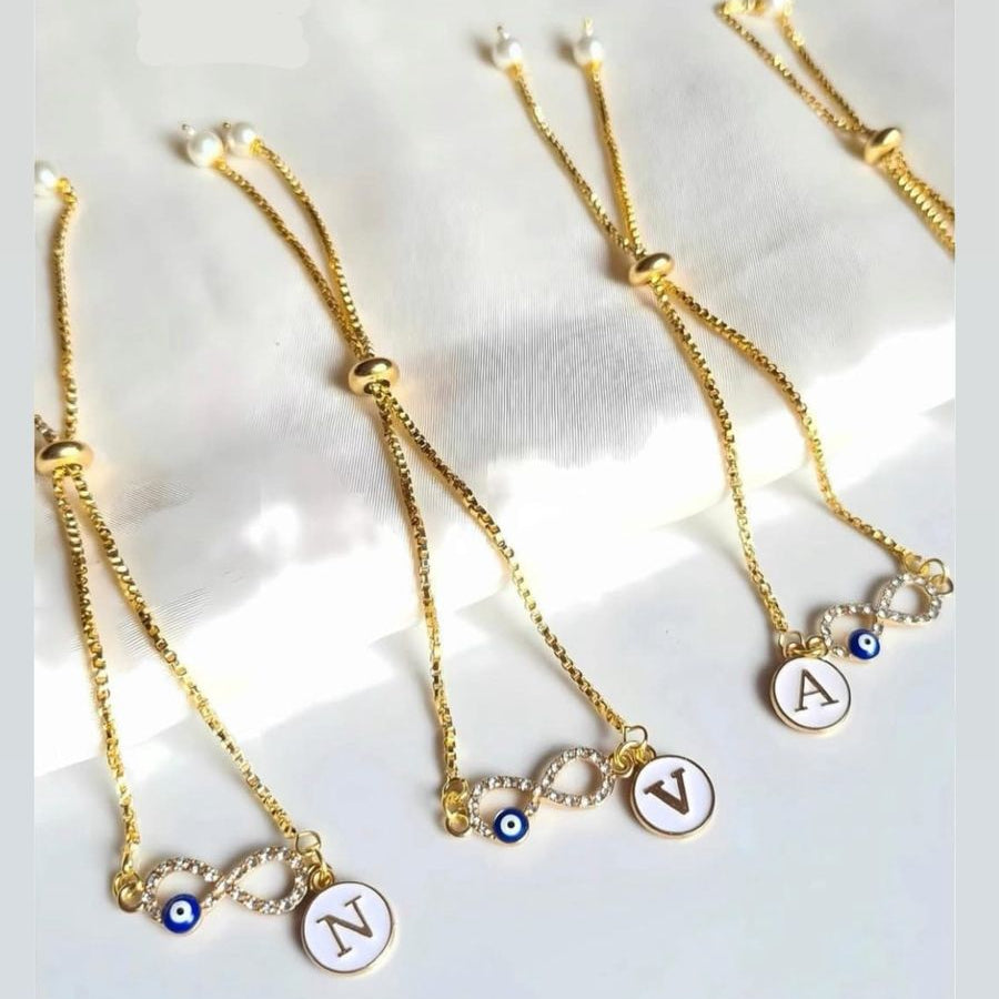 Set of gold necklaces with initial charms on a light background