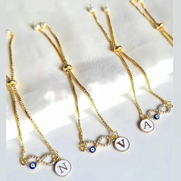Set of gold necklaces with initial charms on a light background